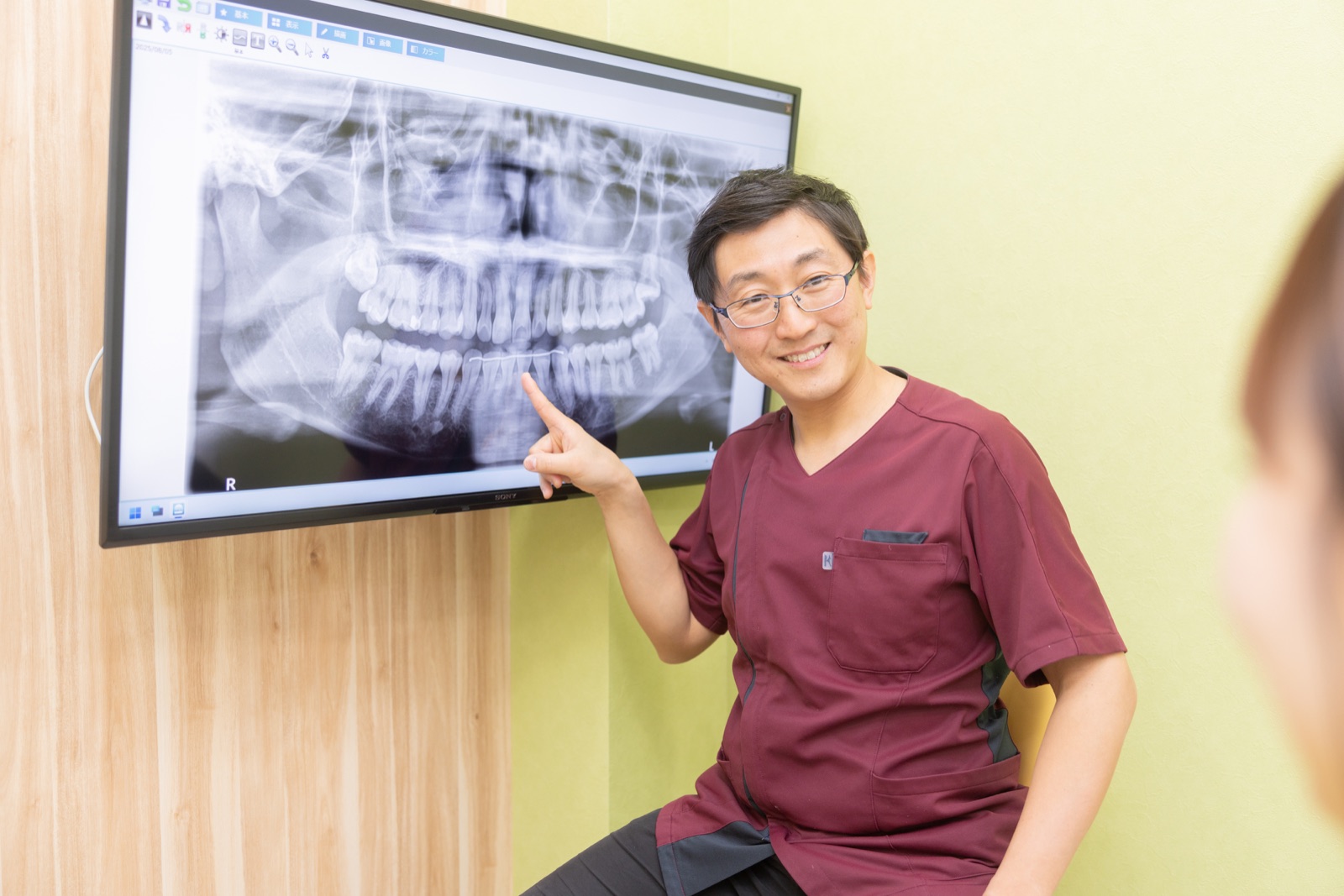 レントゲン画像を示す歯科医師
