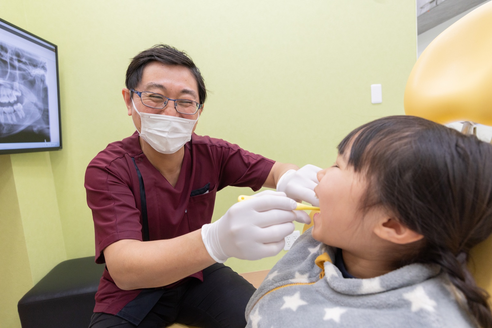 子どもの患者さんを診療する歯科医師